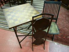 A folding chequer top games table, a black painted folding steamer chair and an Edwardian mahogany