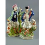 A pair of late 19th Century Staffordshire pottery flatback Scottish kilted figures with dogs, 38 cms