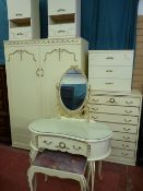 A French style cream and gilt decorated bedroom suite of two door wardrobe, seven drawer chest and