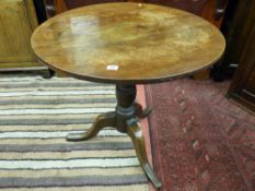 An antique oak circular tripod table with turned baluster support and 75 cms diameter top