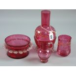 Four pieces of cranberry glass to include an enamel painted rib patterned carafe and beaker, a small