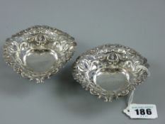 Two hallmarked silver bon bon dishes, heart shaped with pierced edging on three ball feet, marked