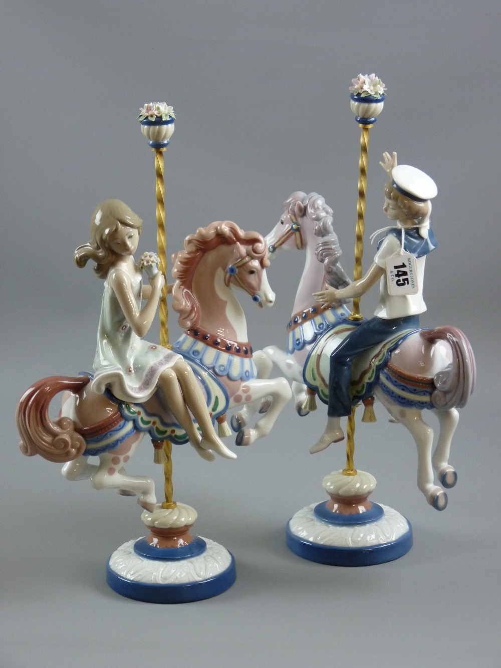 A pair of Lladro pottery 'Carousel Boy' and 'Carousel Girl' figures, 39.5 x 25 cms