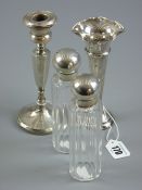 A pair of glass dressing table jars of panelled form with globular silver screw tops, London 1905, a