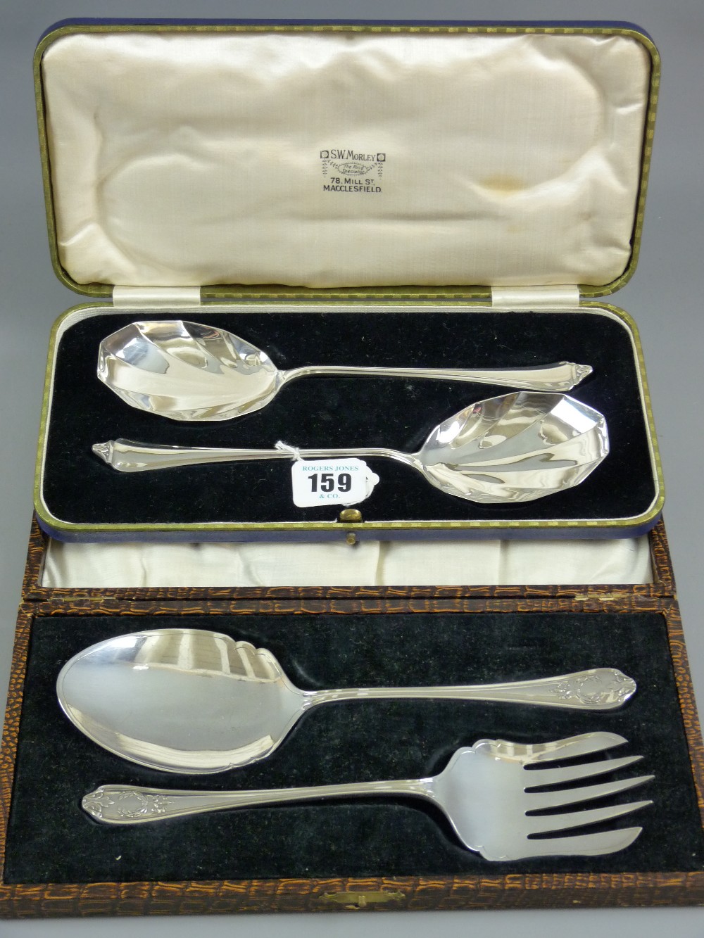 A cased pair of silver serving spoons having tapered handles and sunburst bowls, 4.7 grms, Sheffield