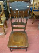 An American comb back farmhouse chair with decorative top rail and solid wood seat on turned