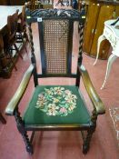 An oak barley twist armchair with crown carved top rail and cane work back, front barley twist