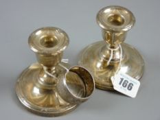 A pair of circular based short stemmed silver candleholders, Birmingham 1921 and a bright cut silver