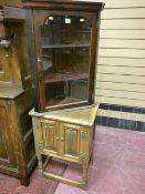 A reproduction Priory style oak two door hutch cupboard on turned supports with cross stretchers and