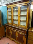 A mid Victorian mahogany and oak three door bookcase cupboard having a glass top and applied