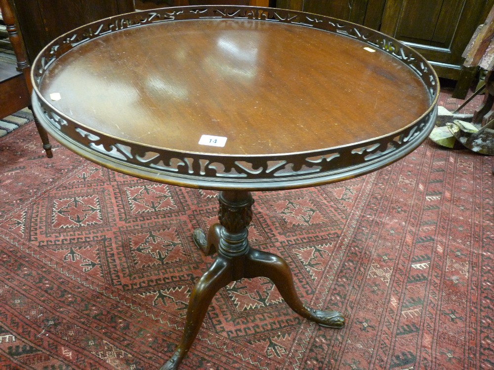 A mid to late 20th Century mahogany 65 cms diameter side table with gallery top, carved column