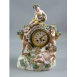 Meissen porcelain - a figural mantel clock with barrel clock housing on a floral encrusted and