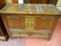 A reproduction Priory style oak mule chest, the three panel lidded top over a centrally carved panel