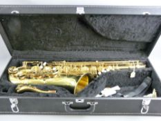 A modern Artemis Mk II brass saxophone in a fitted black leather effect case