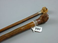 TWO WOODEN WALKING CANES with carved dog's head tops, 90 and 87 cms long