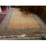 A LARGE PAKISTAN CARPET, rust ground multi bordered with tasselled ends and large block repeat