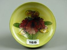 A MOORCROFT ORCHID BOWL, an 11.5 cms diameter bowl with raised rim and foot, decorated on a tonal