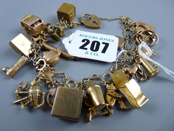 A NINE CARAT GOLD CHARM BRACELET with padlock clasp and over twenty charms including a one arm