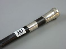 AN EBONIZED SILVER MOUNTED WALKING CANE 84 cms, monogrammed ferrule with 1893 date