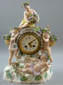 A MEISSEN PORCELAIN CLOCK - a figural mantel clock with barrel clock housing on a floral encrusted