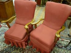 A PAIR OF VINTAGE ARMCHAIRS with shaped wooden arms and red slip over covers, 88 cms high, 60 cms