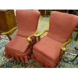 A PAIR OF VINTAGE ARMCHAIRS with shaped wooden arms and red slip over covers, 88 cms high, 60 cms