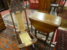 AN OAK BARLEY TWIST GATE LEG TABLE and a Balinese style carved and seagrass seated folding chair