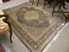 A FINE MAHI TABRIZ PERSIAN CARPET, muted colours with central medallion and floral inner border,