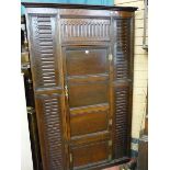A LARGE TWO DOOR OAK CORNER CUPBOARD with carved reeded top and side decoration (fashioned from