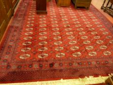 A PRADO ORIENT KESHAN SUPER CARPET, red ground multi repeat pattern with wide border and tasselled