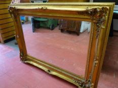 A REPRODUCTION GILT FRAMED WALL MIRROR, deep framed with Rococo style raised and pierced corners, 88