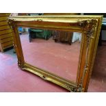 A REPRODUCTION GILT FRAMED WALL MIRROR, deep framed with Rococo style raised and pierced corners, 88