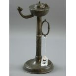 A PEWTER TALLOW LAMP, a circular based pewter tallow lamp with handle to the turned column, 26 cms