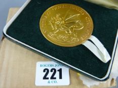 A CASED MEDALLION, a Royal Mint gilt metal 1969 Investiture medallion inscribed in Welsh, 3.2 ozs