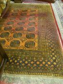 AN AFGHAN CARPET, red ground with tasselled ends, multi bordered with central block pattern (