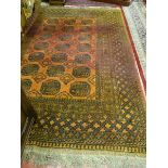 AN AFGHAN CARPET, red ground with tasselled ends, multi bordered with central block pattern (