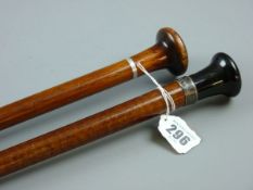 TWO WOODEN SHAFTED WALKING CANES, one with a silver ferrule and a black grip, the other with a white