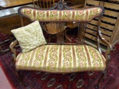 A CIRCA 1900 CARVED MAHOGANY SALON SETTEE with carved and shaped padded top rail, pierced splat back