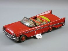 A MID CENTURY AND LATER TINPLATE OPEN TOP CADILLAC friction drive action in red livery with