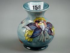 A MOORCROFT COLUMBINE VASE, a 10 cms high vase decorated on a mottled blue ground, impressed '