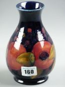 A MOORCROFT POMEGRANATE VASE, a 16 cms high baluster vase decorated on a cobalt blue ground, green