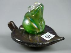 A KRIS HEATON ART GLASS FROG ASTRIDE A LEAF, iridescent green and glass sculpture, inscribed to