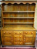 AN EARLY 19TH CENTURY ANGLESEY OAK DRESSER, the three shelf shape sided rack with decorative top