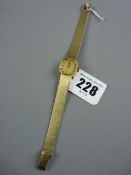 A FOURTEEN CARAT GOLD ENCASED LADY'S SQUARE DIAL WRISTWATCH with round corners and incorporated