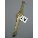 A FOURTEEN CARAT GOLD ENCASED LADY'S SQUARE DIAL WRISTWATCH with round corners and incorporated