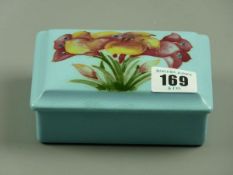 A MOORCROFT FREESIA TRINKET BOX, a rectangular trinket box and cover decorated on an unusual light