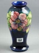 A MOORCROFT CLEMATIS VASE, a 23 cms high baluster vase patterned on a cobalt blue and mottled