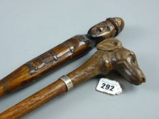 TWO CARVED WOODEN WALKING CANES, one in the form of a dog's head with glass eyes and white metal