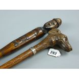 TWO CARVED WOODEN WALKING CANES, one in the form of a dog's head with glass eyes and white metal