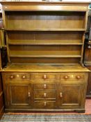 AN ANGLESEY OAK AND PINE DRESSER, mid 19th Century, shaped three plate rack with wide back boards on